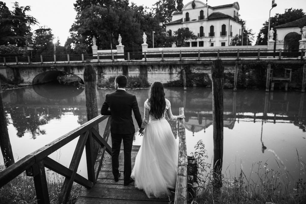 Melissa e Nicolò sulla passerella davanti a un fiume per una prova foto di matrimonio